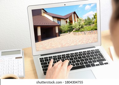 Businesswoman or real estate agent looking through online property portfolio using laptop, closeup