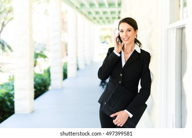 Businesswoman Real Estate Agent Talking On Mobile Phone On Veranda