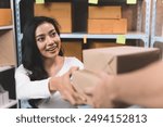 businesswoman receiving parcels from delivery man with happiness from shipping company. Young women with new business about online shopping in home office and small store.