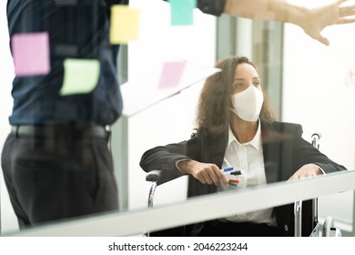 Businesswoman returning from treatment in a wheelchair wear a mask Must come back to work. The concept is marketing, finance, physically handicapped, Covid 19, orange light. - Shutterstock ID 2046223244