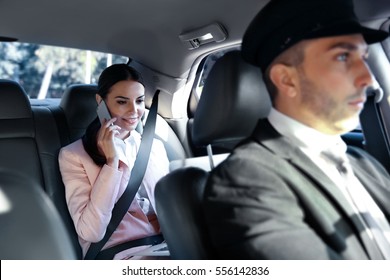 Businesswoman riding a car with chauffeur - Powered by Shutterstock