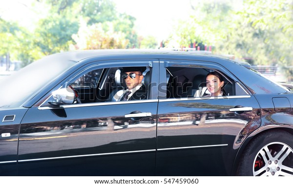 Businesswoman riding a car\
with chauffeur
