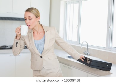 Businesswoman Rushing Out The Door To Work In The Morning At Home In The Kitchen