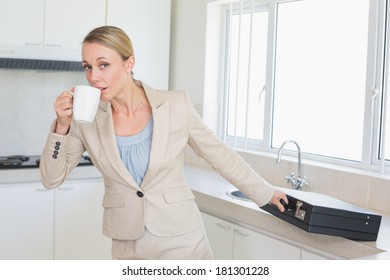 Businesswoman Rushing Out The Door To Work In The Morning At Home In The Kitchen