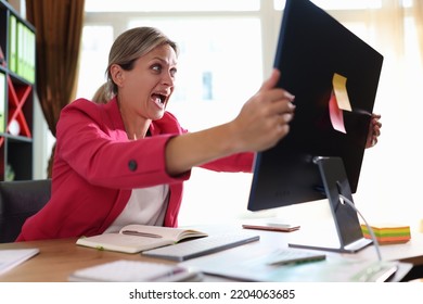 Businesswoman Screaming Hysterically At Computer Monitor In Office. Shocked Woman Financial Mistake Bad News And Online Blackout