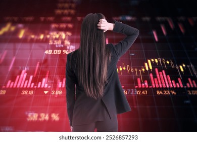 A businesswoman seen from the back, observing stock market charts with falling trends in red on a dark background. Concept of financial crisis - Powered by Shutterstock