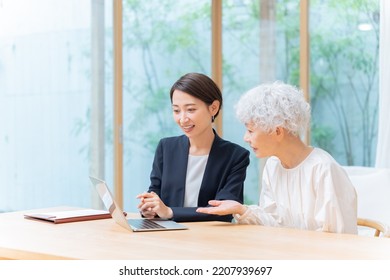 Businesswoman And Senior Woman Looking At Laptop Computer