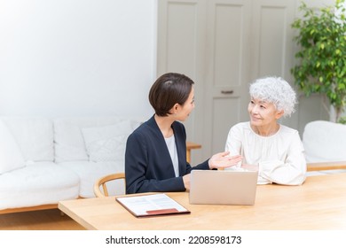 Businesswoman And Senior Woman Looking At Laptop Computer