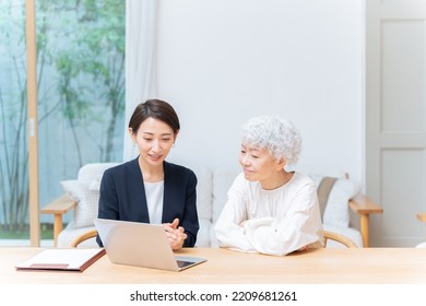 Businesswoman And Senior Woman Looking At Laptop Computer