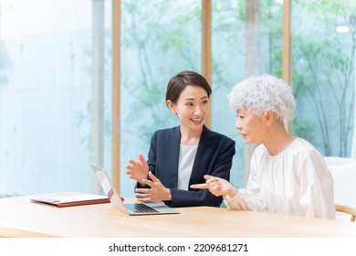 Businesswoman And Senior Woman Looking At Laptop Computer