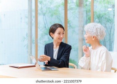 Businesswoman And Senior Woman Looking At Laptop Computer