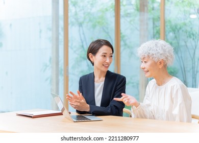 Businesswoman And Senior Woman Looking At Laptop Computer