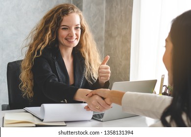 Businesswoman shaking hands with supplier and thumb up for good offer deal.