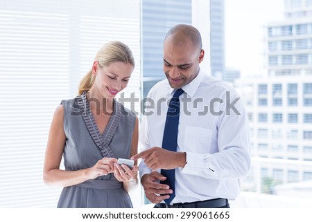 Businesswoman showing her phone to her colleague in the office
