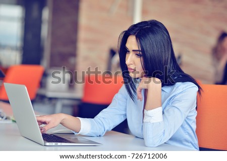 Businesswoman sits at a desk in front of a computer