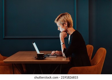 Businesswoman sitting in a cafe while focused on working on a laptop and participating in an online meetings. Selective focus. High quality photo - Powered by Shutterstock