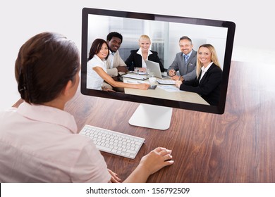 Businesswoman Sitting At A Desk Watching An Online Presentation On The Computer