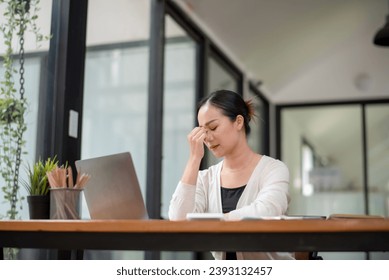 Businesswoman sitting in front of laptop considering office work.  Think hard and take your work seriously. Stressed with assigned work. - Shutterstock ID 2393132457