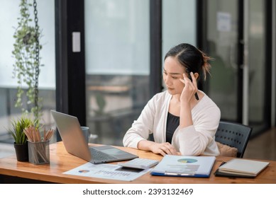 Businesswoman sitting in front of laptop considering office work.  Think hard and take your work seriously. Stressed with assigned work. - Shutterstock ID 2393132469