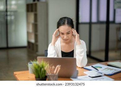 Businesswoman sitting in front of laptop considering office work.  Think hard and take your work seriously. Stressed with assigned work. - Shutterstock ID 2393132475