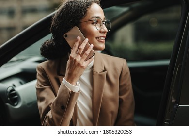 Businesswoman Sitting In Her Car And Talking On Phone. Woman In Businesswear Making A Phone Call While Sitting In Her Car.