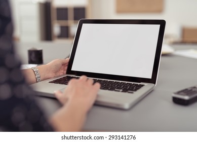 Businesswoman Sitting At Her Desk Navigating The Internet On A Laptop Computer Using The Trackpad, Over The Shoulder View Of The Blank Screen