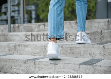 A businesswoman in sneakers conquers the city stairs, symbolizing her determined path. Each step reflects her unwavering progress towards success, highlighting her professional growth. step up