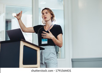 Businesswoman speaking from a podium in a seminar. Female professional addressing a conference. - Powered by Shutterstock