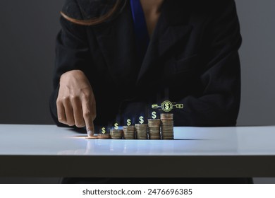 Businesswoman stacking coins with virtual graph. Income Management and saving money concepts - Powered by Shutterstock