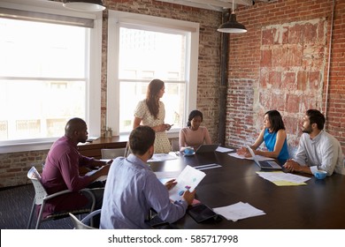 Businesswoman Standing To Address Boardroom Meeting - Shutterstock ID 585717998