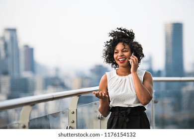 A businesswoman standing against London view panorama, making a phone call. - Powered by Shutterstock