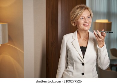 Businesswoman Standing Near The Door In Hotel Room, Calling On Phone