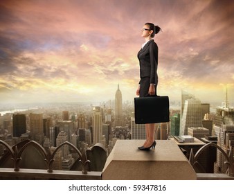 Businesswoman standing on the rooftop of a skyscraper - Powered by Shutterstock