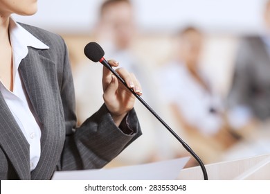 Businesswoman standing on stage and reporting for audience - Powered by Shutterstock