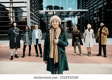 Businesswoman Standing Out From A Diverse Group Of Business People While Posing Together Outside The Office Building.