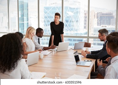 Businesswoman Stands To Address Meeting Around Board Table - Shutterstock ID 633351596