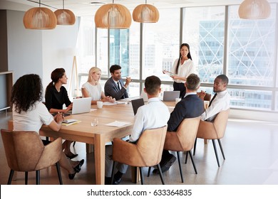 Businesswoman Stands To Address Meeting Around Board Table - Shutterstock ID 633364835