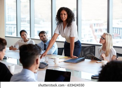Businesswoman Stands To Address Meeting Around Board Table - Shutterstock ID 633424550