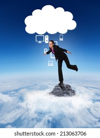 Businesswoman Stepping And Balancing Against Mountain Peak Through The Clouds