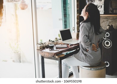 Businesswoman suffering from pain of lower back - Shutterstock ID 1069550198