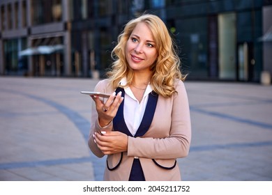 Businesswoman In Suit Is Talking By Smartphone Using Speakerphone.