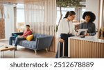 Businesswoman With Suitcase Checking In At Hotel Reception For Conference