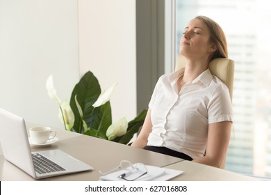Businesswoman takes short time-out in office work. Beautiful girl lying relaxed on back chair. Female entrepreneur resting at workplace. Comfortable office furniture for long work in sitting position 