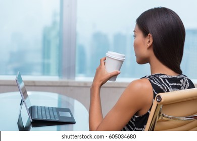 Businesswoman Taking A Coffee Break At Work Looking Out The Window Thinking About Career Opportunities Or Life Goals. Asian Business Woman Drinking Hot Drink In Office.