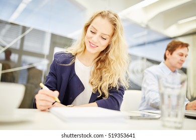 Businesswoman Taking Notes During A Business Meeting