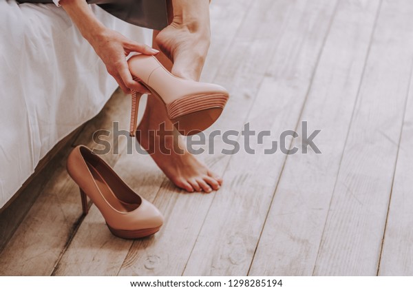 仕事の後 ハイヒールの靴を脱ぐビジネスマン 彼女の脚の接写 の写真素材 今すぐ編集