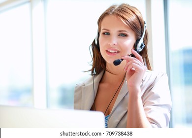 Businesswoman talking phone while working on her computer at the office - Shutterstock ID 709738438