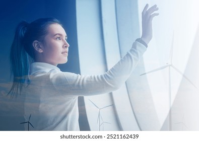 Businesswoman touching a digital interface with wind turbines in background. Businesswoman touching wind turbines digital interface. Technology and Renewable energy concept. - Powered by Shutterstock