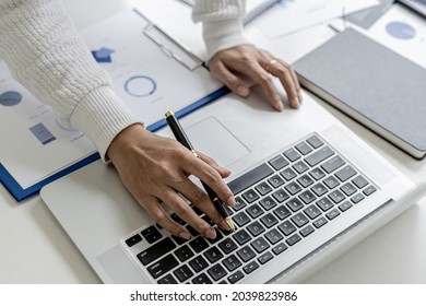 A businesswoman typing on a laptop, she is talking to an employee using a laptop messenger to inquire about company finances. The concept of using technology to assist in communication.
