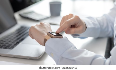 Businesswoman uses a smartwatch to make reminders or keep a small note of important messages on her wristwatch. Use of technology in work, Reminder Assistant,Watch time, Touch screen.